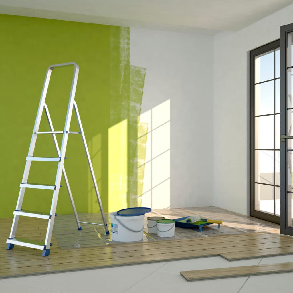Rénovation d'une pièce: mur partiellement peint en vert clair, échelle, pots de peinture, sol stratifié en pose, lumière du soleil.